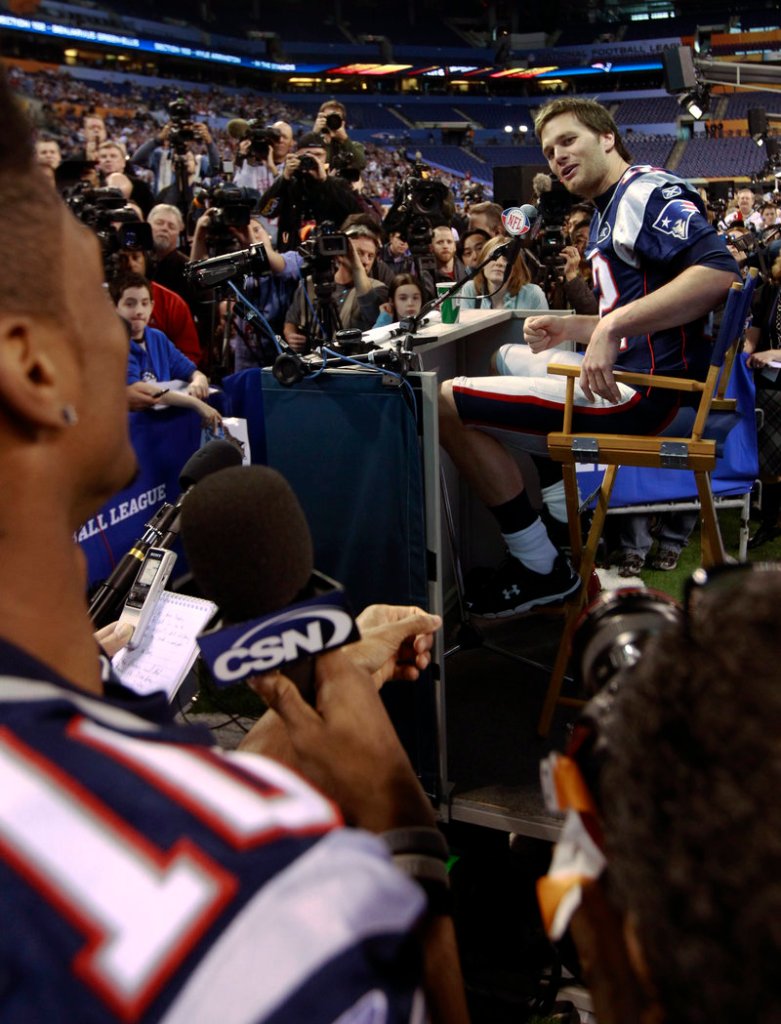 New England Patriots quarterback Tom Brady answers a question from teammate Tiquan Underwood during Media Day for NFL football's Super Bowl XLVI on Tuesday in Indianapolis.