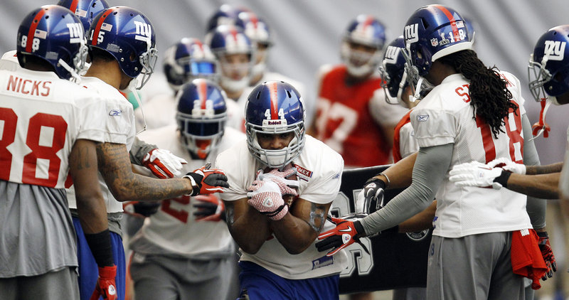 Ahmad Bradshaw of the Giants goes through drills on Wednesday in Indianapolis. Bradshaw has played through pain for most of the season, missing four games after breaking a bone in his right foot in late October.