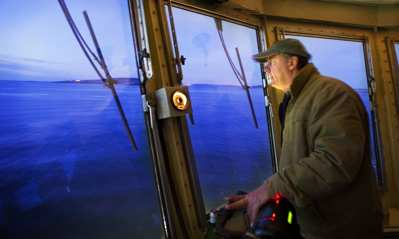 Gene Willard peers out into a pre-dawn sea of blue on his morning ferry run to the islands.