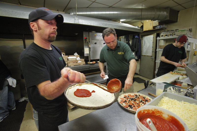 James Fowler, left, David Lengyel, center, and Duayne Frank make pizzas at Willows Pizza & Restaurant in South Portland on Friday evening. Lengyel, owner of Willows, expects to be cranking out the pizzas through the first half of the Super Bowl on Sunday.