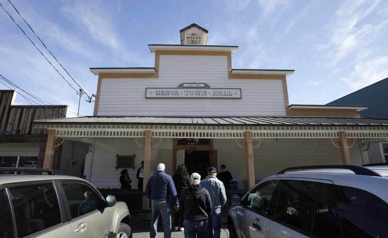 Voters arrive at the Genoa Town Hall for a Nevada Republican caucus meeting Saturday in Genoa, Nev. The economy still figures to be the chief issue in the presidential campaign.