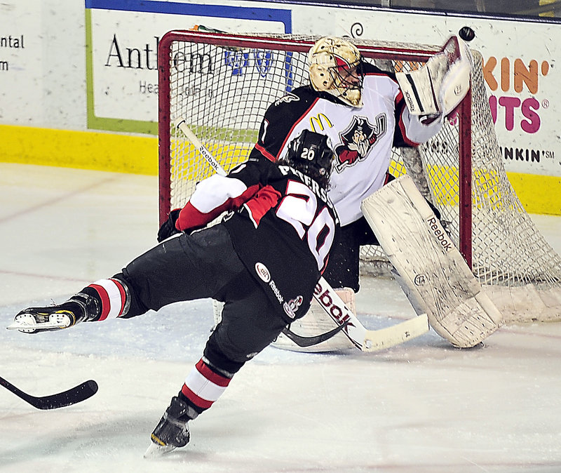 Portland goalie Justin Pogge stands his ground and knocks away a shot by Andre Petersson of the Binghamton Senators in the first period Saturday night. Portland won, 5-2.