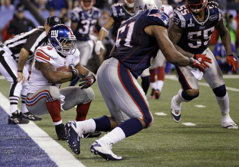 Giants running back Ahmad Bradshaw falls backward into the end zone to score the winning touchdown with 57 seconds left in the Super Bowl. The Patriots allowed Bradshaw to score to get the ball back with time left on the clock, but their final drive ended with a failed Hail Mary pass.