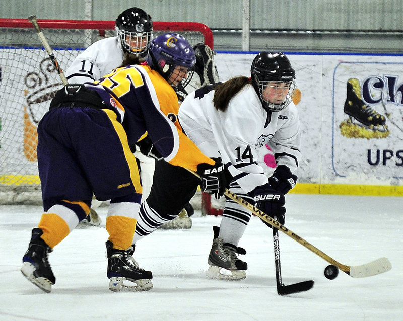 Kylie Dalbec of Portland-Deering breaks up an attempt by Elyse Caiazzo of Cheverus in front of goalie Leanne Reichert on Wednesday. Dalbec had two goals and two assists as Portland-Deering advanced with a 6-2 victory at the Portland Ice Arena.