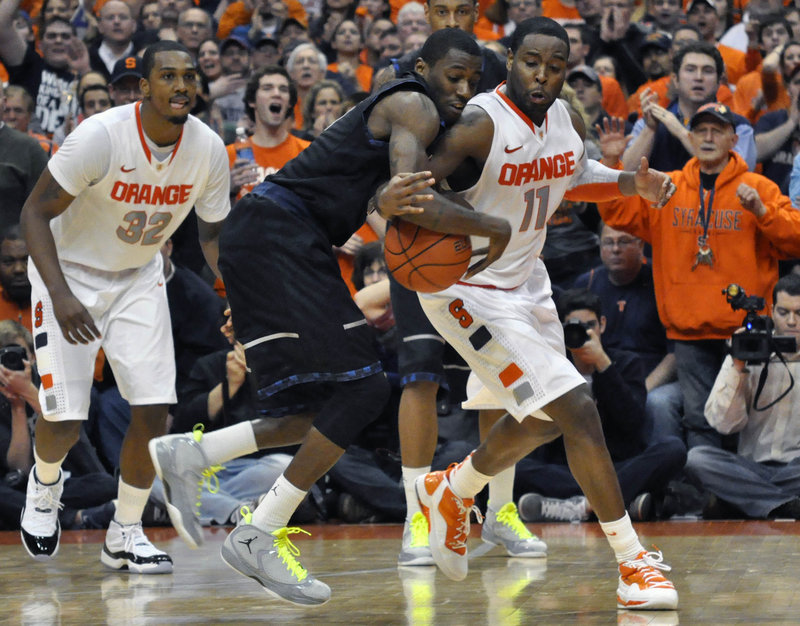 Scoop Jardine of Syracuse knocks the ball loose from Georgetown’s Jason Clark to force a turnover to end the game Wednesday night in Syracuse, N.Y. The Orange won in OT, 64-61.