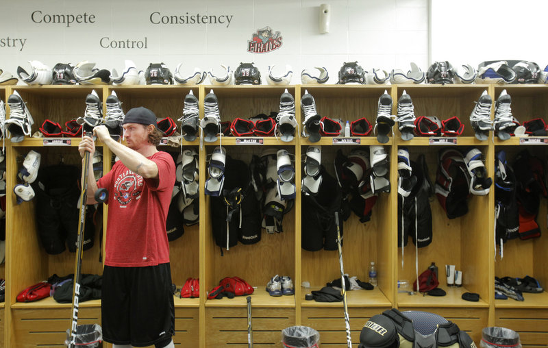 Alexandre Bolduc tapes the top of his hockey stick in a Portland Pirates locker room in the Cumberland County Civic Center after a recent practice. The center’s renovation is expected to expand and improve space for the resident hockey team and for student tournaments.
