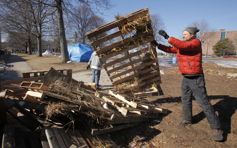 Sam Swenson, an Occupy protester who didn’t live at the camp, throws a pallet onto a pile in Lincoln Park on Friday.