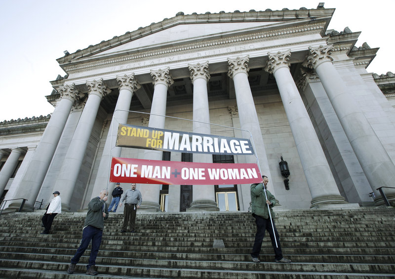 Ken Jackson, right, and Don Taylor carry a sign that reads “Stand Up For Marriage – One Man + One Woman” following a rally at the Capitol in Olympia, Wash., on Jan. 23. Same-sex marriage is back in the political spotlight.