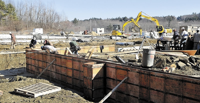 Workers build the foundation for the new Kennebec Ice Arena on Friday in Hallowell. It will replace the old arena, the roof of which collapsed last winter under a load of snow.