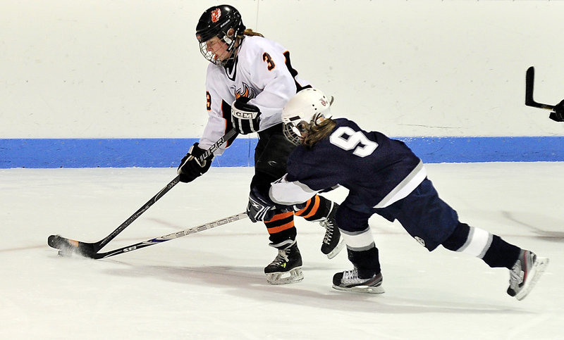 Michelle Robichaud of Yarmouth-Freeport attempts to slow Ann Kelly of Brunswick and knock the puck away at Brunswick.