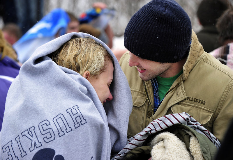 Meghan Eslinger of Kittery is warmed by Scott Batson of Portsmouth, N.H., after she took the plunge at East End Beach. It was Eslinger's first polar dip.
