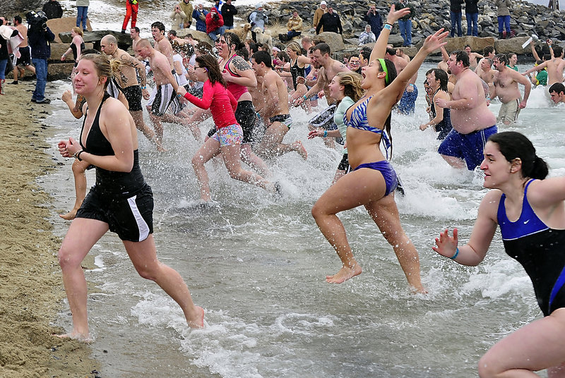 Participants rush out of the water only seconds after they took the plunge in Camp Sunshine’s Freezin’ for a Reason Portland Polar Dip at East End Beach on Saturday. The event raised enough to increase the number of families at the camp from 750 to 762.