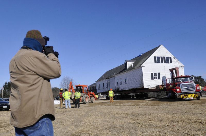 Kevin Byron, a local photographer and volunteer with the Arundel Historical Society, photographs the Burnham farmhouse Sunday as it is moved to its new location off Limerick Road in Arundel. The Burnham house and the Lunt farmhouse were donated to the historical society.