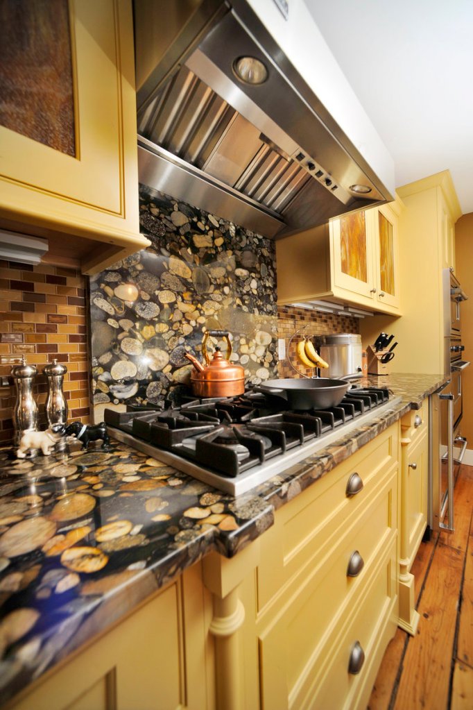 Colors in the countertops and backsplash coordinate with the buttercream-yellow cabinetry.