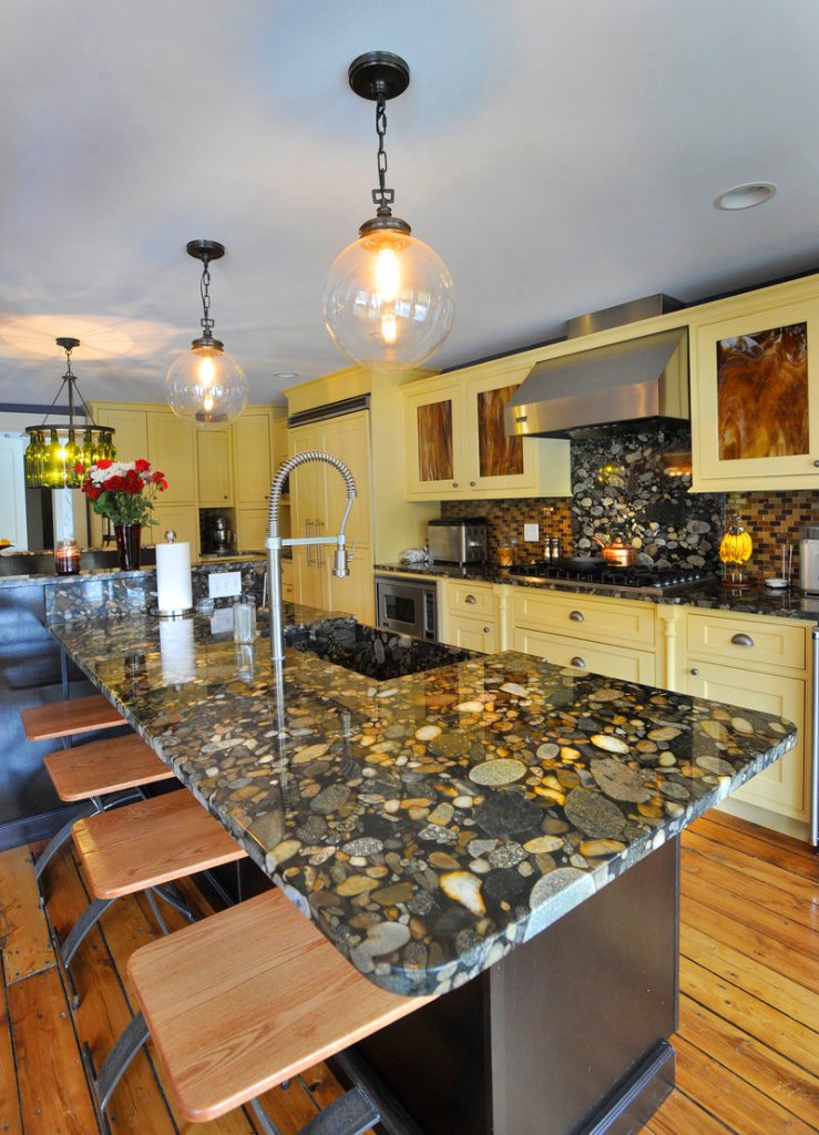 Stunning marinace granite tops the kitchen island and counters, and resembles river rock under water.