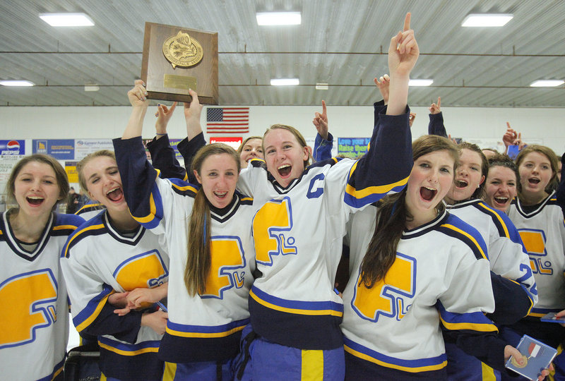Falmouth captains Megan Fortier, third from left, and Monica Aaskov lift the trophy Wednesday night after the Yachtsmen won the West championship in girls’ hockey with a 4-0 victory against York. Falmouth will meet Greely for the state championship Saturday night.