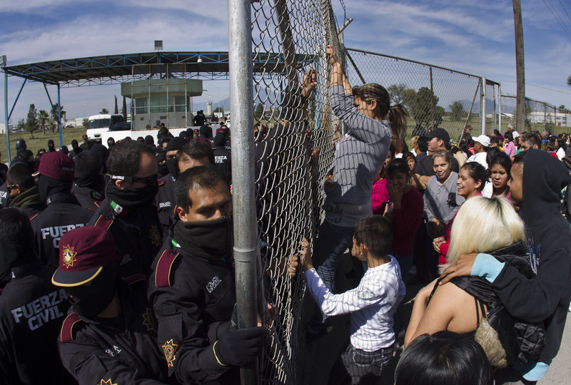 Police hold back relatives of inmates outside Apodaca correctional state facility as they try to get past the gates on the outskirts of Monterrey, Mexico, on Sunday, when a riot left 44 inmates dead.