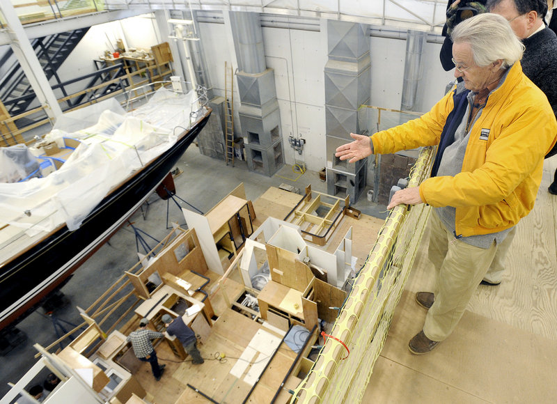 At Lyman-Morse Boatbuilding of Thomaston, Stanley Paris gets a bird’s-eye view Wednesday as workers construct the interior of his Paris 63 sailboat below.