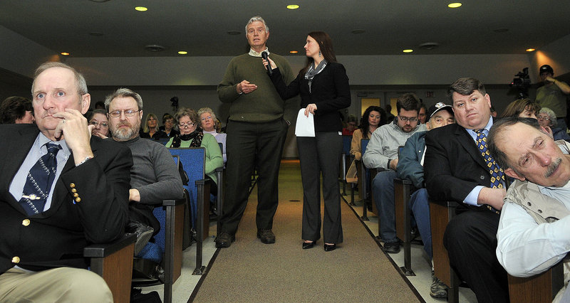 Adrienne Bennett, spokeswoman for Gov. Paul LePage, holds the microphone for Bob Farley of Norridgewock as he asks a question regarding public funding of religious schools during a town hall meeting Thursday at Madison Area Junior High School.
