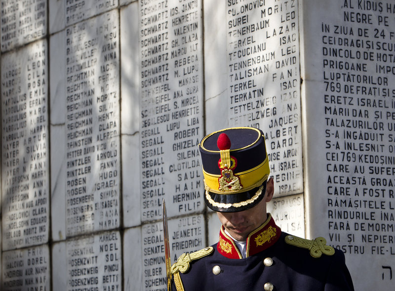 An honor guard soldier in Bucharest, Romania, stands at a monument at a Jewish cemetery with the names of Jews killed 70 years ago when the SS Struma was sunk.