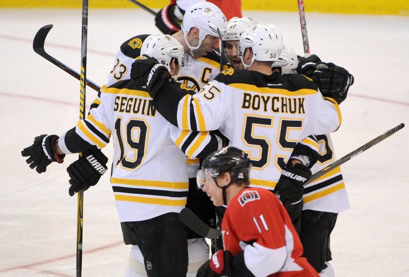 Patrice Bergeron of the Bruins, rear right, celebrates his goal with teammates Zdeno Chara, rear left, Tyler Serguin and Johnny Boychuk in Saturday’s game at Ottawa. The Bruins won, 5-3.
