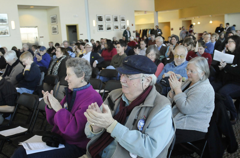 Julia Adams and Eliot Stanley of Portland applaud along with others as Portland Democrats announce their support for President Obama during their caucus Sunday at Ocean Gateway.