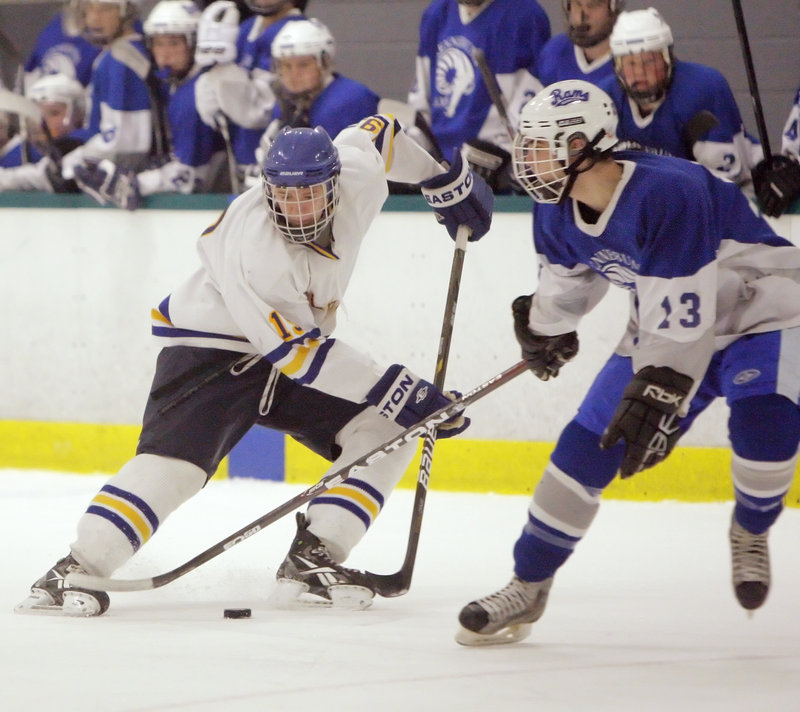 Ben Freeman, left, who scored five goals for Falmouth, attempts to skate around Nick Manuel of Kennebunk.