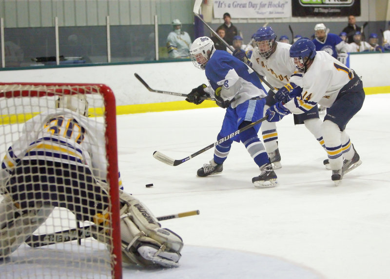 Jack Kennedy of Kennebunk tries to put a shot on Falmouth goalie Dane Pauls while being challenged by Ben Freeman, center, and Jack Pike. Falmouth advanced to the Western Class A semifinals by pulling away to a 10-1 victory Tuesday night.