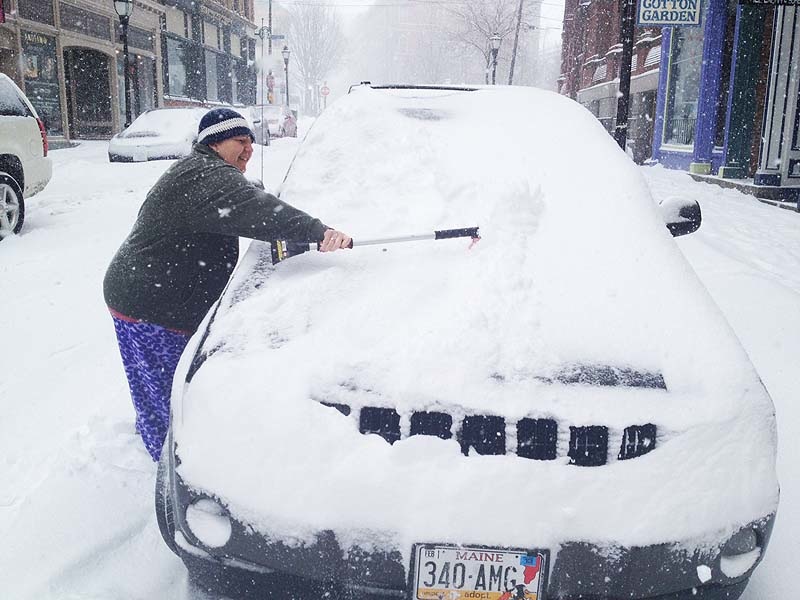 Dot Merrill of Portland cleans her car on Exchange St. so she can get to a doctor's appointment on Thursday morning, March 1, 2012.