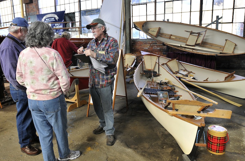 Steve Kaulback, founder of Adirondack Guideboat Inc., out of Charlotte, Vt., talks with visitors during The Maine Boatbuilders Show at the Portland Company Complex on Sunday, March 18, 2012.