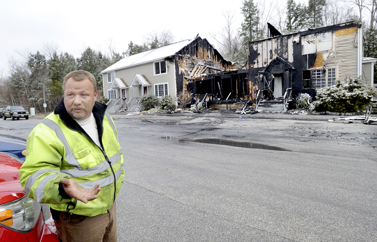 Casey Farley stands outside his gutted condo at 20 Calla Way in Windham after he awoke to flames outside his window and alerted his family and adjacent neighbors to safety.