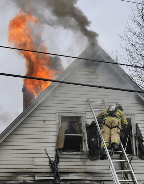 A firefighter battles the fire at 28 Raymond St. in Biddeford Saturday morning March 31, 2012.