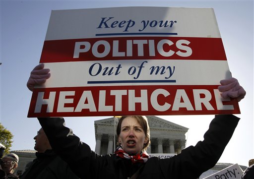 Amy Brighton from Medina, Ohio, who opposes health care reform, rallies in front of the Supreme Court in Washington on Tuesday. The court continues arguments today on the health care law signed by President Barack Obama.