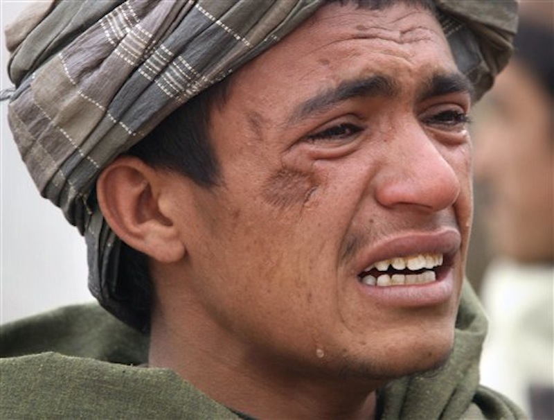An Afghan youth mourns for relatives, who were allegedly killed by a U.S. service member in Panjwai, Kandahar province south of Kabul, Afghanistan on Sunday, March. 11, 2012. A U.S. service member walked out of a base in southern Afghanistan before dawn Sunday and started shooting Afghan civilians, according to villagers and Afghan and NATO officials. Villagers showed an Associated Press photographer 15 bodies, including women and children, and alleged they were killed by the American. (AP Photo/Allauddin Khan)