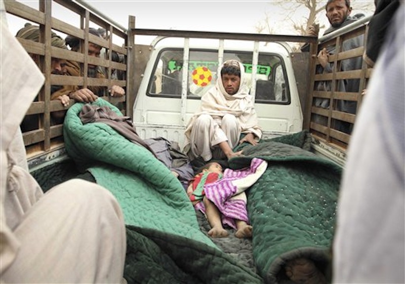 A man sits in the back of a truck with the bodies of several men and a child allegedly killed by a U.S. service member in Panjwai, Kandahar province south of Kabul, Afghanistan on Sunday, March 11, 2012. A U.S. service member walked out of a base in southern Afghanistan before dawn Sunday and started shooting Afghan civilians, according to villagers and Afghan and NATO officials. Villagers showed an Associated Press photographer 15 bodies, including women and children, and alleged they were killed by the American. (AP Photo/Allauddin Khan)