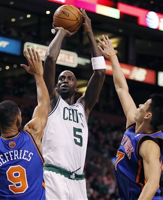 Boston Celtics' Kevin Garnett (5) shoots over New York Knicks' Jared Jeffries (9) and Jeremy Lin, right, in the second quarter of an NBA basketball game in Boston on Sunday, March 4, 2012. (AP Photo/Michael Dwyer)