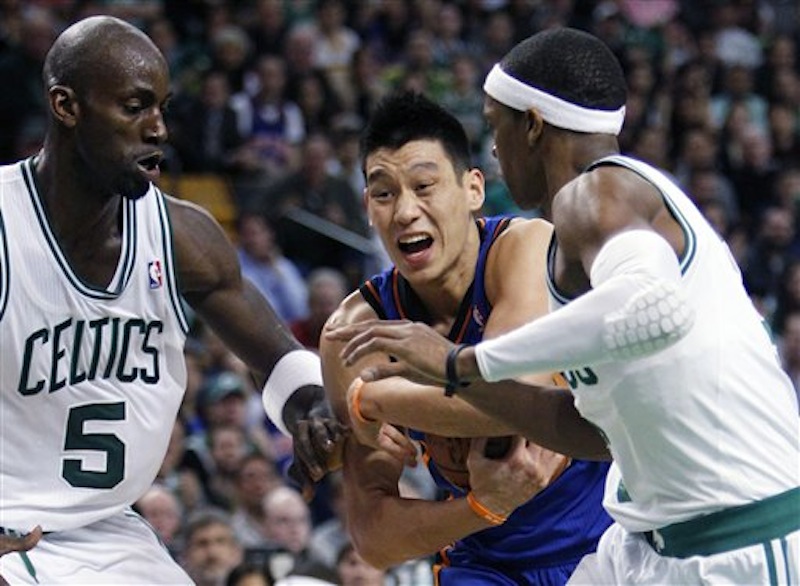 New York Knicks' Jeremy Lin, center, holds on to the ball between Boston Celtics' Kevin Garnett (5) and Rajon Rondo in the fourth quarter of an NBA basketball game in Boston on Sunday, March 4, 2012. The Celtics won 115-111 in overtime. (AP Photo/Michael Dwyer)