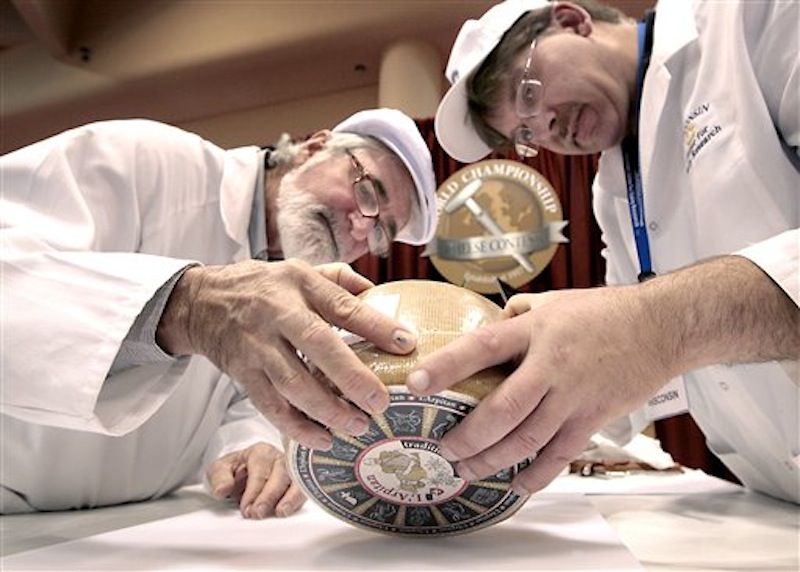 Russell Smith of Australia, left, and John Jaeggi of Madison prepare to sample one of the entries in the Smear Ripened Semi-soft Cheese category during the opening day of the World Championship Cheese Contest at the Monona Terrace Convention Center in Madison, Wis. on Monday, March 5, 2012. More than 2,500 entries will be judged throughout the three day gathering, sponsored every two years by the Wisconsin Cheese Makers Association. (AP Photo/Wisconsin State Journal, John Hart ) LOCAL;A3;CHEESE;WORLD CHAMPIONSHIP;DAIRY;JUDGE;MONONA TERRACE