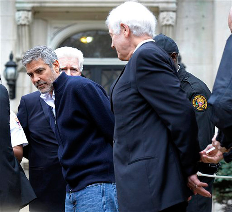 Actor George Clooney, center, Rep. Jim Moran, D-Va, back, and Clooney's father, Nick Clooney, right, are arrested during a protest at the Sudanese Embassy in Washington on Friday, March 16, 2012. The demonstrators are protesting the escalating humanitarian emergency in Sudan that threatens the lives of 500,000 people. (AP Photo/Cliff Owen)