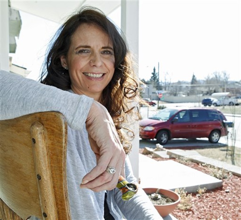 In this photo taken on Tuesday, March 6, 2012, Angeline Chilton a suburban Denver woman with multiple sclerosis who smokes pot twice a day to ease tremors, holds her pipe as she sits on the front porch of her home in Lakewood, Colo. States are struggling to come up with a blood-level standard for marijuana that would be analogous to the blood-alcohol standard used to decide who's driving drunk. (AP Photo/Ed Andrieski)