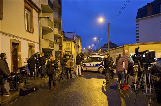 Journalists gather nearby as French police secure the area today where they exchanged fire and were negotiating with a gunman who claims connections to al-Qaida and is suspected of killing three Jewish schoolchildren, a rabbi and three paratroopers.