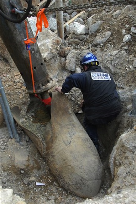 This photo shows a de-mining expert examining a German bomb dating from World War II, before it was defused and removed in southern France on Sunday, March 18, 2012. Officials in Marseille are evacuating an area around the French Mediterranean city's port so they can remove a 1-ton German bomb that dates to World War II. (AP Photo/Bataillons Marins-Pompiers de Marseille)