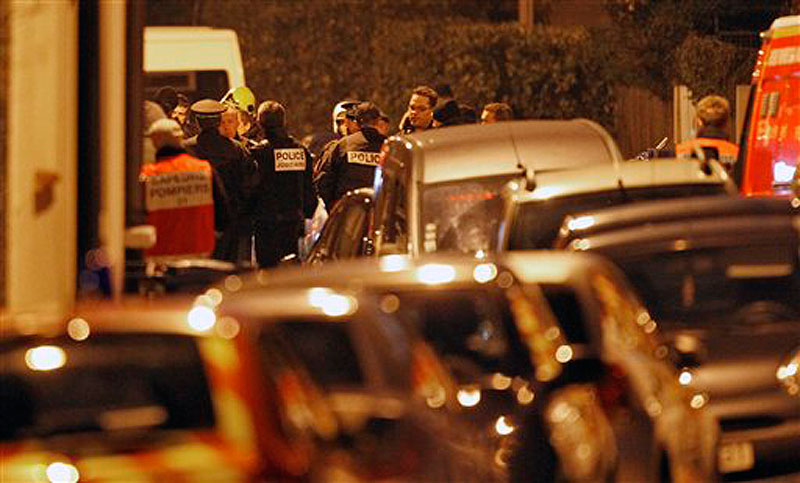 French police officers and firefighters stand at night next to the apartment building where a suspect in the shooting at the Ozar Hatorah Jewish school is still barricaded, in Toulouse, Southern France on Wednesday, March 21, 2012. A predawn police raid on a home in Toulouse erupted into a firefight Wednesday with a gunman who claims connections to al-Qaida and is suspected of killing three Jewish schoolchildren, a rabbi and three paratroopers. (AP Photo/Christophe Ena)
