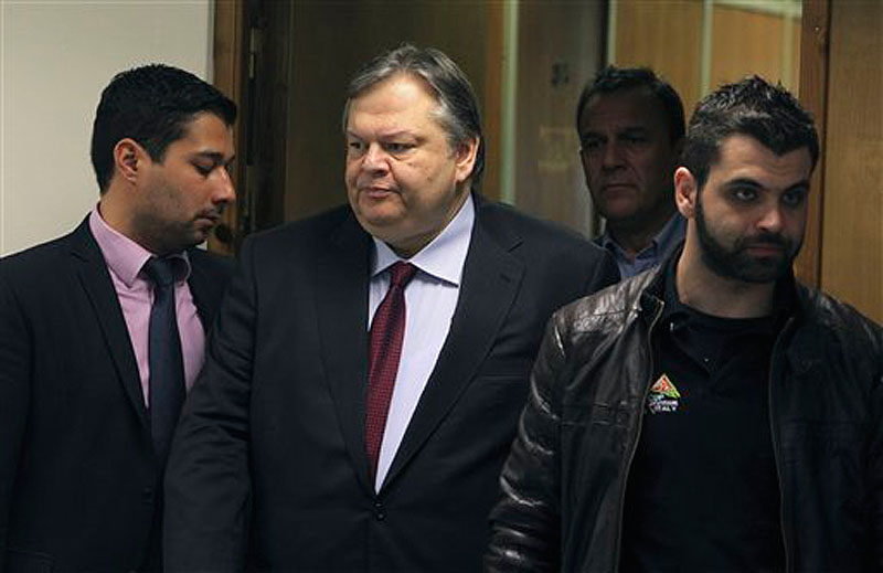 Greece's Finance Minister Evangelos Venizelos, center, surrounded by his personal security arrives for a news conference in Athens on Friday, March 9, 2012. Greece has cleared a major hurdle in its race to avoid imminent bankruptcy after persuading the vast majority of its private creditors to slash the value of their Greek bond holdings, a move that should pave the way for the country's second massive international bailout. (AP Photo/Thanassis Stavrakis)