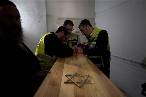 Israeli burial officials prepare the coffins of Toulouse shooting victims for their funeral, after they arrived to Israel, at a morgue in Jerusalem today.