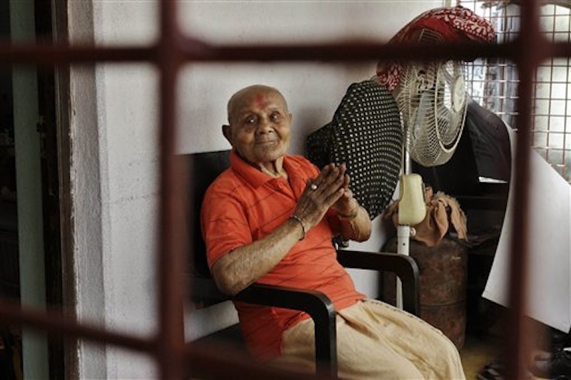 Indian body builder Manohar Aich sits in the balcony in Kolkata, India on Sunday, March 18, 2012. Aich, a former Mr. Universe who has just turned 100 said Sunday, that happiness and a life without tensions are the key to his longevity. Aich, who is 4 foot 11 inches (150 centimeters) tall, overcame many hurdles, including grinding poverty and a stint in prison, to achieve body building glory. (AP Photo/Bikas Das)