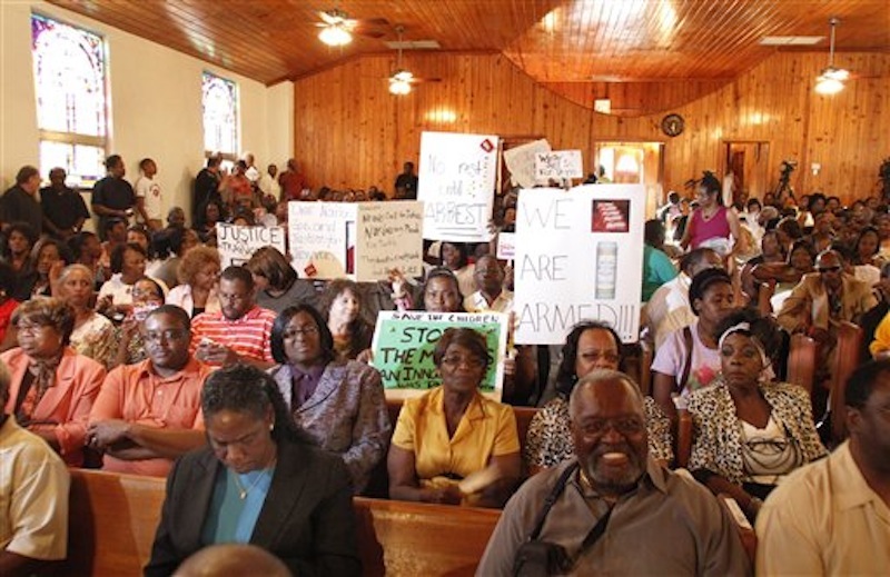 A group gathers in a church and chants "we want justice" on Tuesday, March. 20, 2012, in Sanford, Fla. in protest against the lack of prosecution in reference to the shooting death of 17 year old Trayvon Martin who was shot and killed by George Zimmerman a neighborhood watchman. (AP Photo/Reinhold Matay)