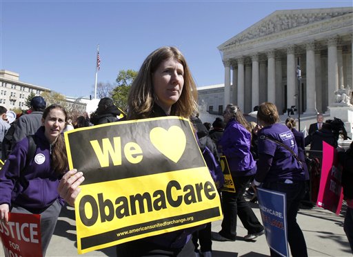 Holding a sign saying "We Love ObamaCare," supporters of health care reform rally in front of the Supreme Court on Tuesday.