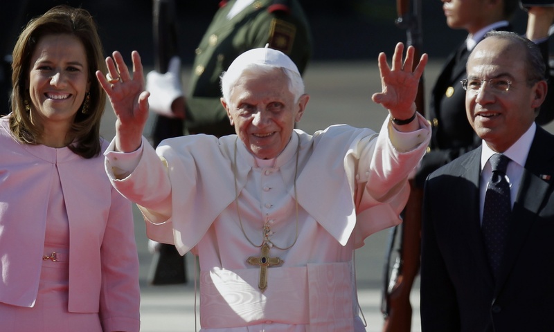 Pope Benedict XVI, accompanied by Mexico's President Felipe Calderon, right, and his wife Margarita Zavala, waves as he arrives at the airport in Silao, Mexico on Friday.