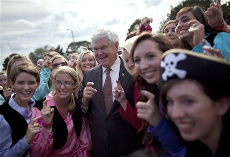 Republican presidential candidate Newt Gingrich poses for photos with the "Pirates of the Spanish Maine" high school sorority before a rally, Friday, March 2, 2012, in Brunswick, Ga. (AP Photo/Evan Vucci)
